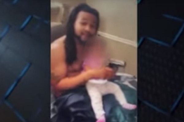 Da li je on normalan? Stavio napunjen pištolj bebi u ruke i pravio se da puca! (VIDEO)