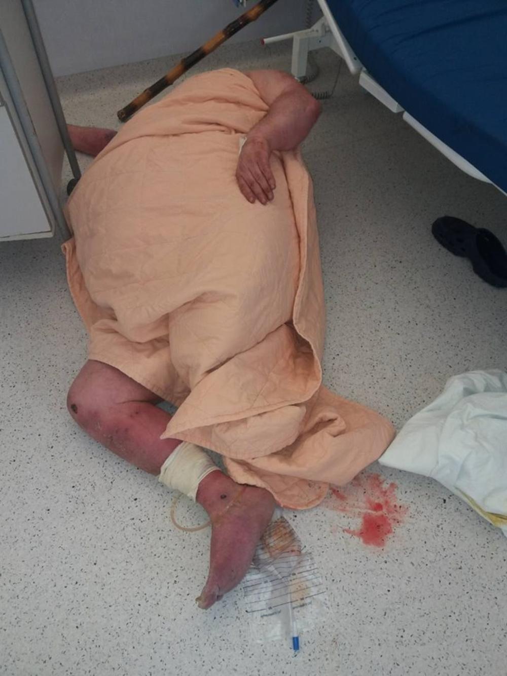 Nesrećni čovek leži na podu bolnice       