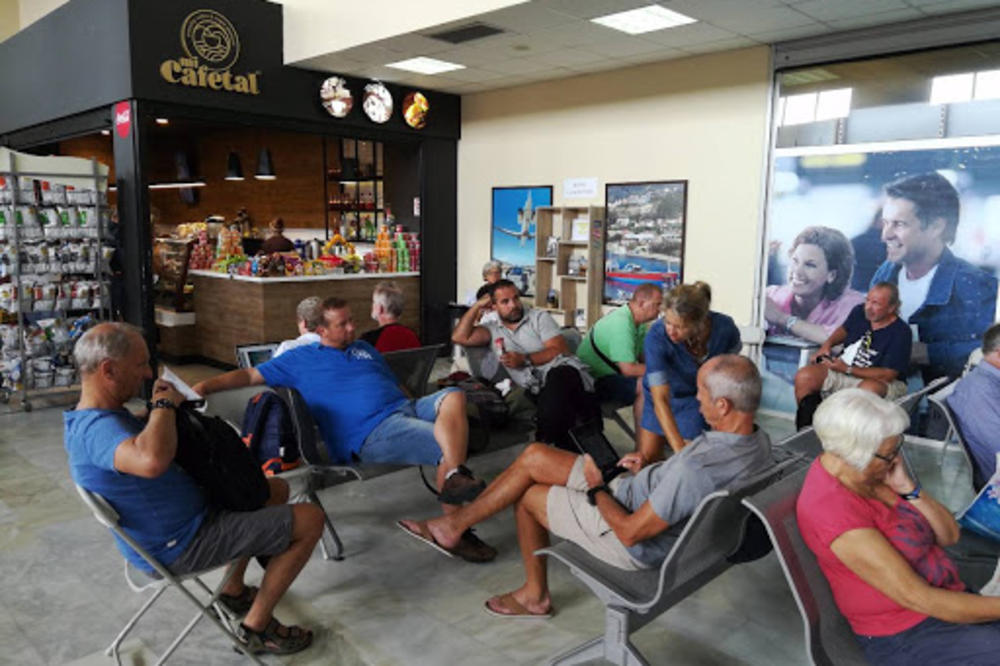 SRBI ZAROBLJENI NA AERODROMU NA SKIJATOSU, U OČAJU SEDE I ČEKAJU: Trebalo je da polete jutros u 8.35, ali im je let odložen za danas u 17!(FOTO)