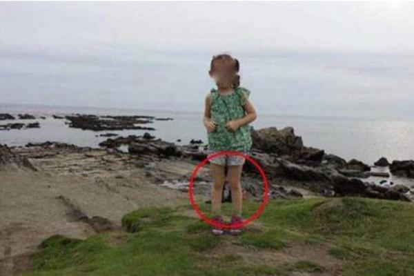 FOTOGRAFISAO JE ĆERKU NA OBALI MORA: Ono što je ugledao između NJENIH NOGU na slici ga je ZAPREPASTILO! (FOTO)