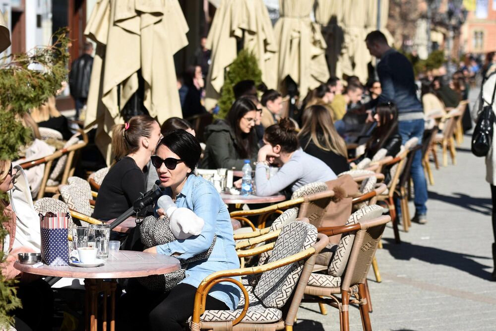 U kafiću deca i ljudi po lepom vremenu