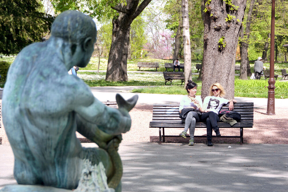 Devojke sede u parku po lepom danu