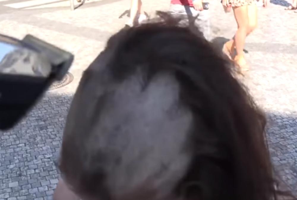 Devojka se šiša na ulici za novac  