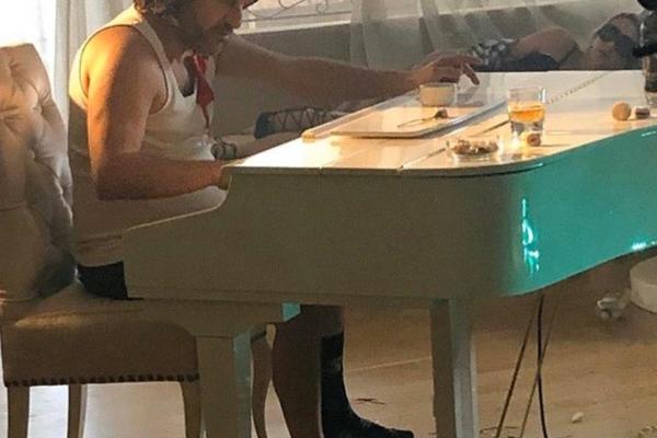 ACA LUKAS U GAĆAMA I SILEDŽIJKI ZA KLAVIROM, RASPARENE ČARAPE NA NOGAMA: A oko njega haos, prazne flaše i pune čaše