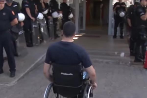 ČOVEK U KOLICIMA S KRSTOM U RUCI STAO PRED POLICIJU! Poslao im je poruku od koje im nije bilo dobro! (VIDEO)