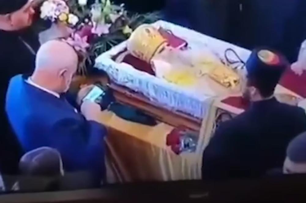 SNIMAK SA SAHRANE AMFILOHIJA POTRESAO JAVNOST! Čovek pozira i traži da ga slikaju dok ljubi preminulog mitropolita