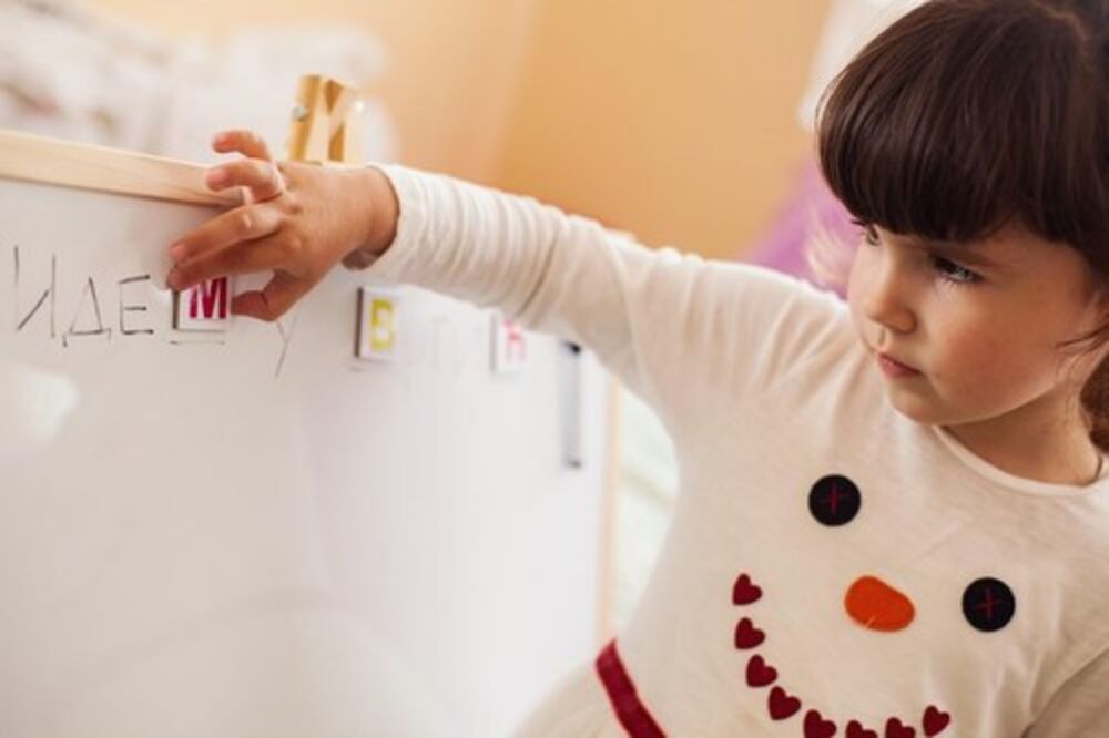 Devojčica piše na tabli