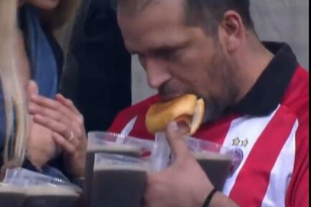 TAJ LUDI FUDBAL! Navijač Crvene zvezde zalutao na meč Bundes lige - jede hot dog i drži 8 piva u rukama! (VIDEO)