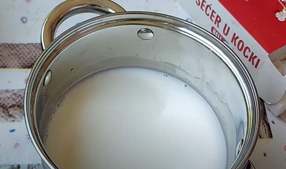 U šerpu sa debelim dnom, sipajte mleko, pirinač, šećer, korice narandže i limuna, cimet i vanilu