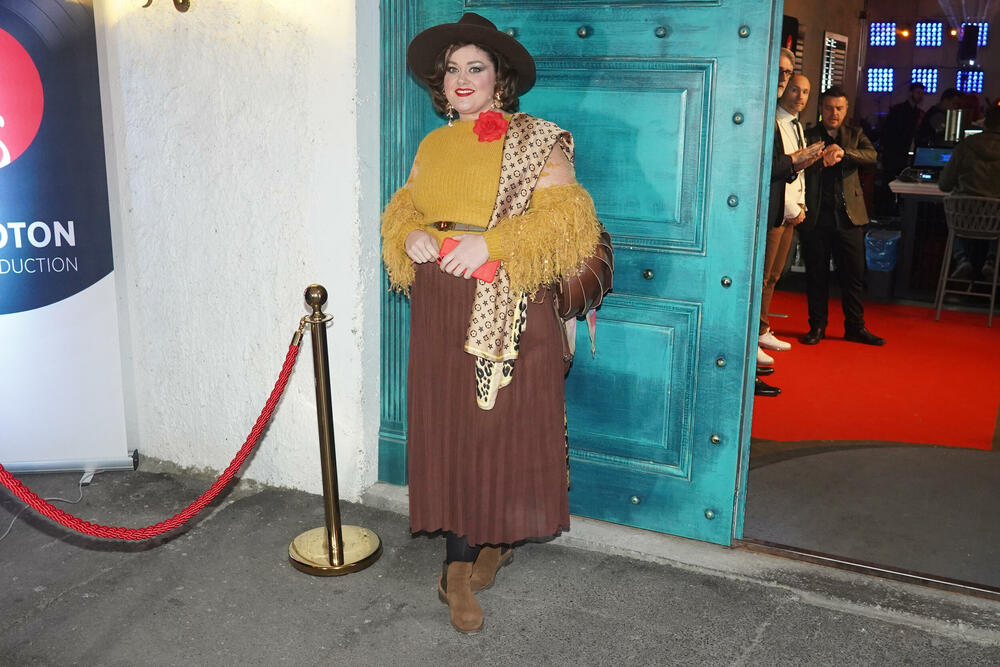 Bojana je nosila blago plisiranu suknju u braon nijansi, a gore je imala neobičnu džemper bluzu 