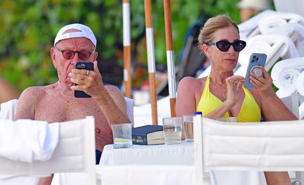 Rupert Merdok i En Lesli Smit gledaju u telefone