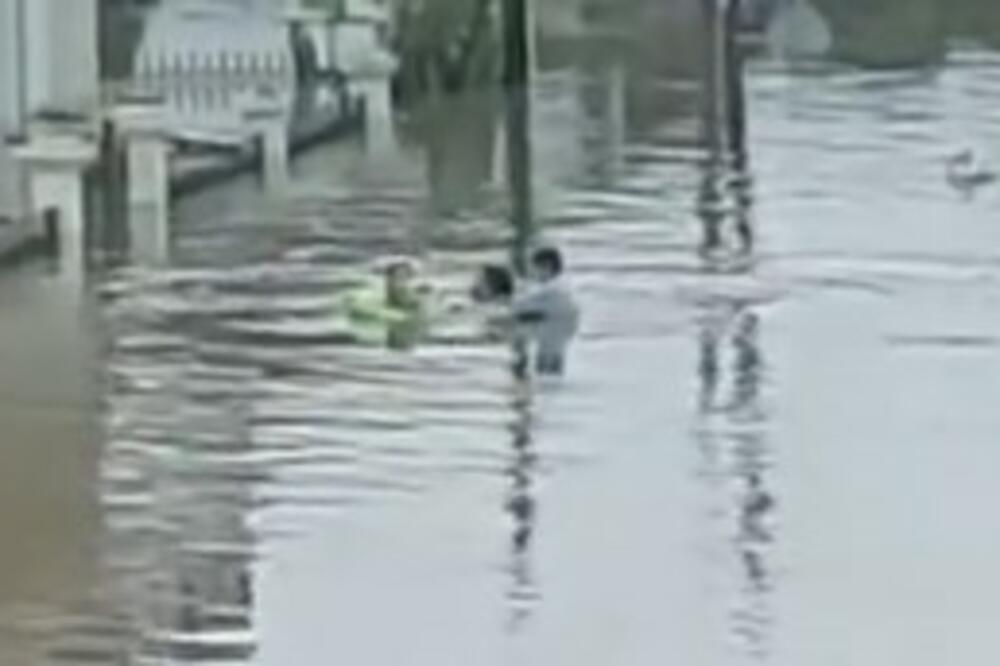 POTRESNA SCENA U GRČKOM MESTU: Žena vuče decu u gumenom čamcu, voda joj stigla DO GUŠE (VIDEO)