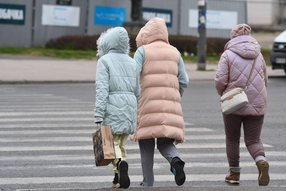 Žene u jaknama prelaze ulicu 