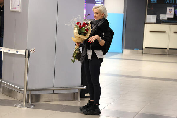 VODITELJKA U USKIM HELANKAMA I KRATKOJ JAKNI POKAZALA ZGODNO TELO: Evo koga je ČEKALA sa CVEĆEM U RUKAMA