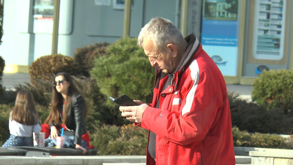 U telefon gleda stariji penzioner