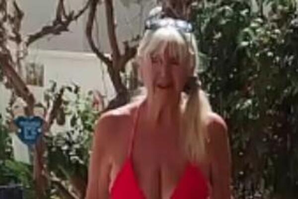 IMA 93 GODINE I NON STOP SE SKIDA POLUGOLA: Voli da joj SVI vide GRUDI samo u TANKOM CRVENOM kupaćem (VIDEO)