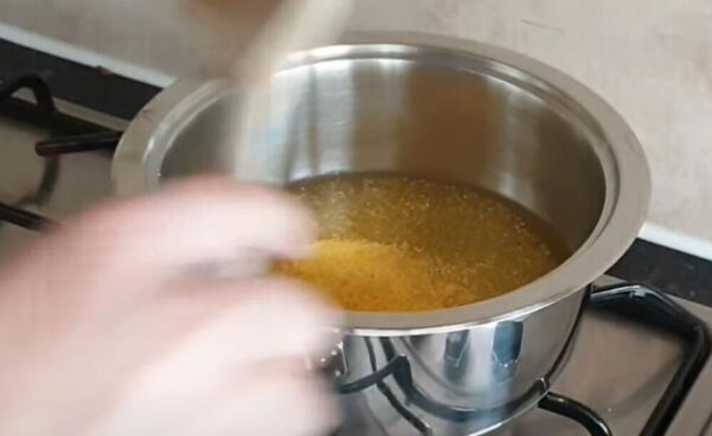 Stavljanje kukuruznog brašna u šerpu sa vodom