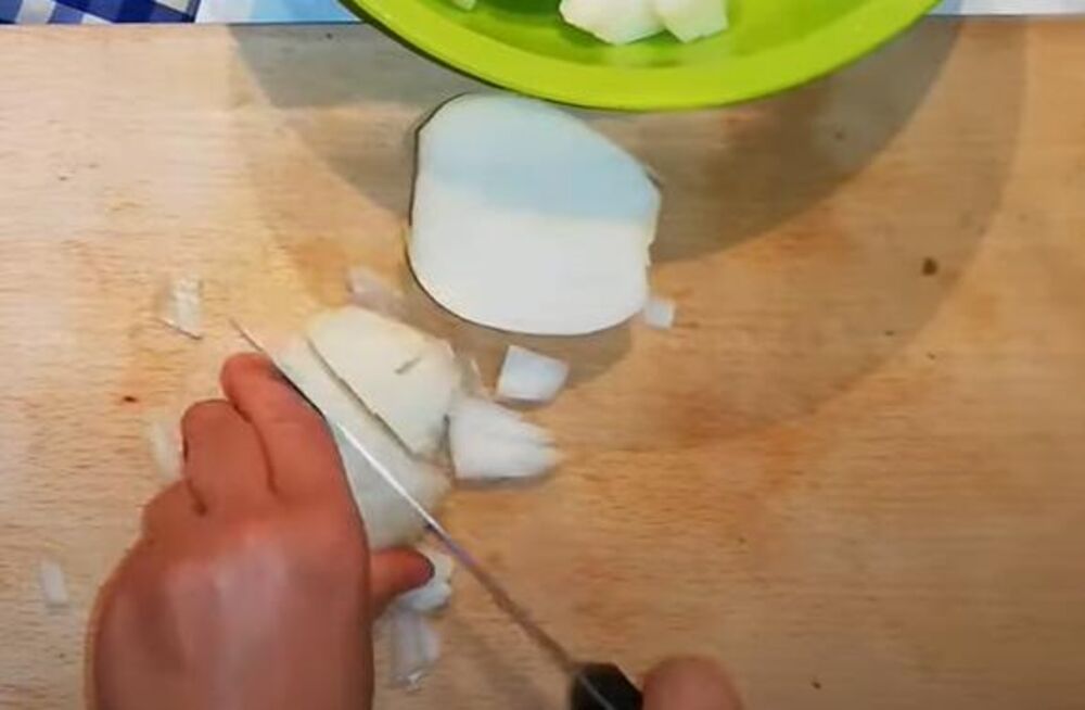 Seckanje crnog luka za pripremu ribe na pirinču