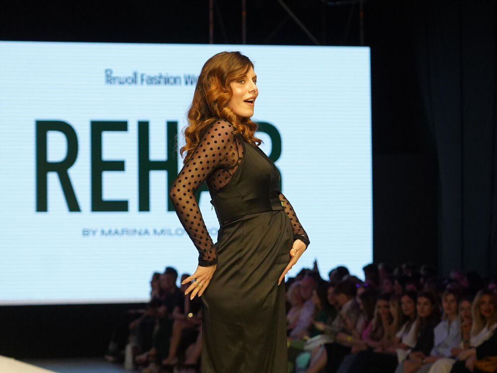 Ona je nosila haljinu midi dužine u crnoj boji 