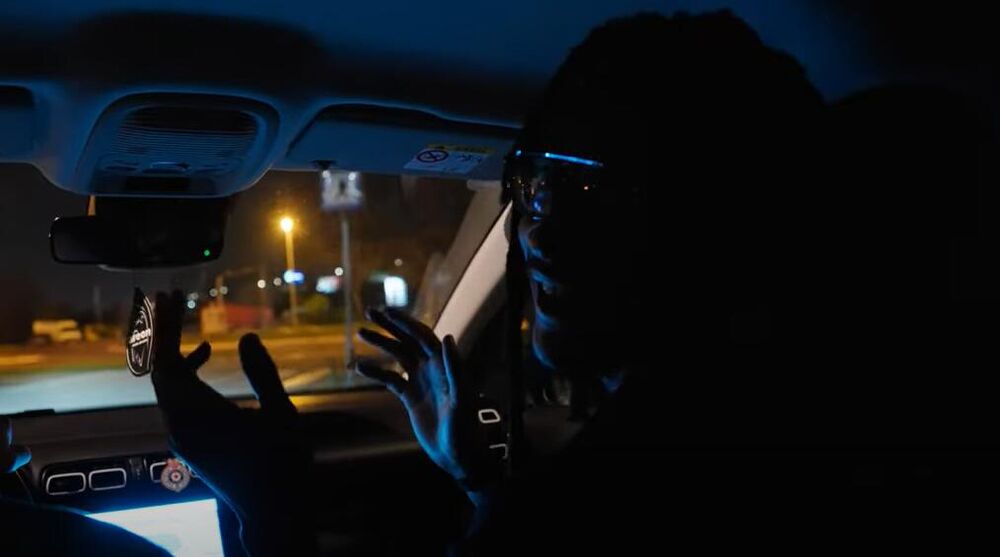 Čima Moneke u kolima i levo grb Partizana