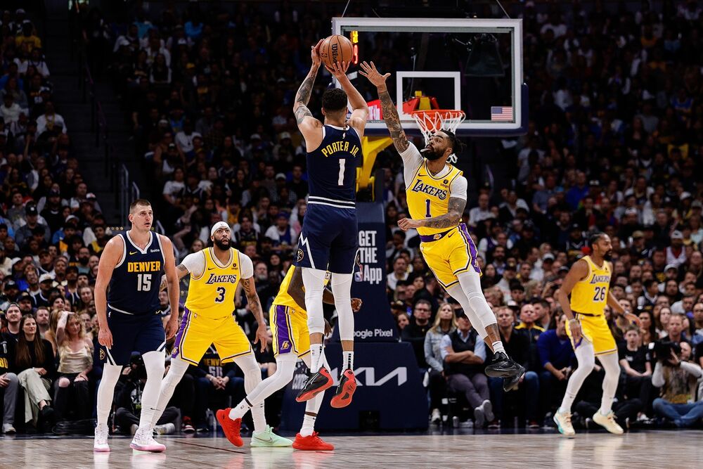 Majkl Porter Džunior šutira preko Dianđela Rasela na utakmici Nagetsa i Lejkersa