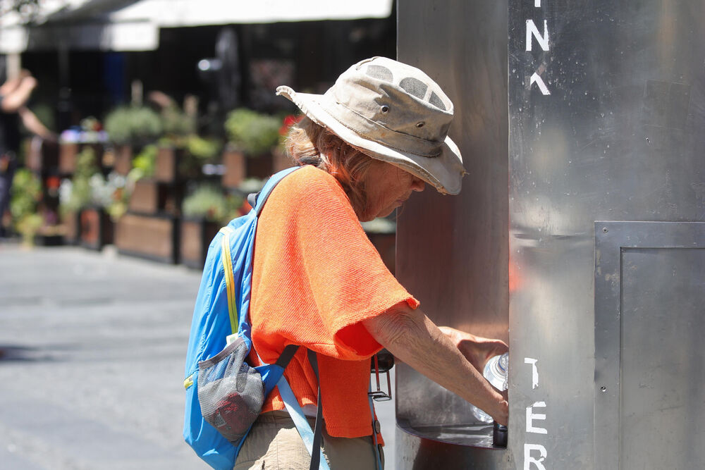 Žena toči vodu po vrućini
