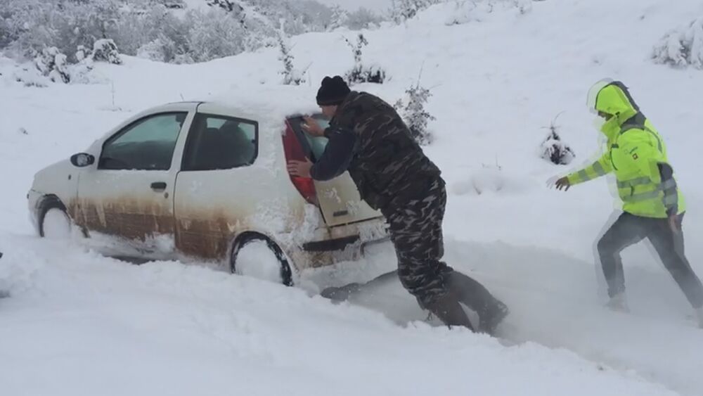 Ljudi goraju kola po snegu