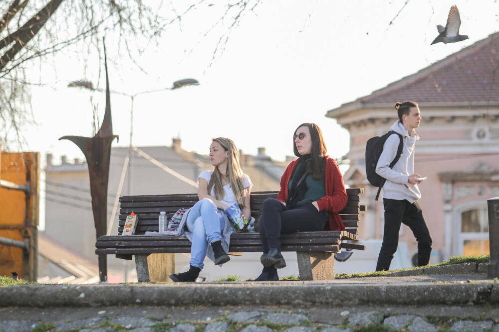 Žene na klupi sede u parku